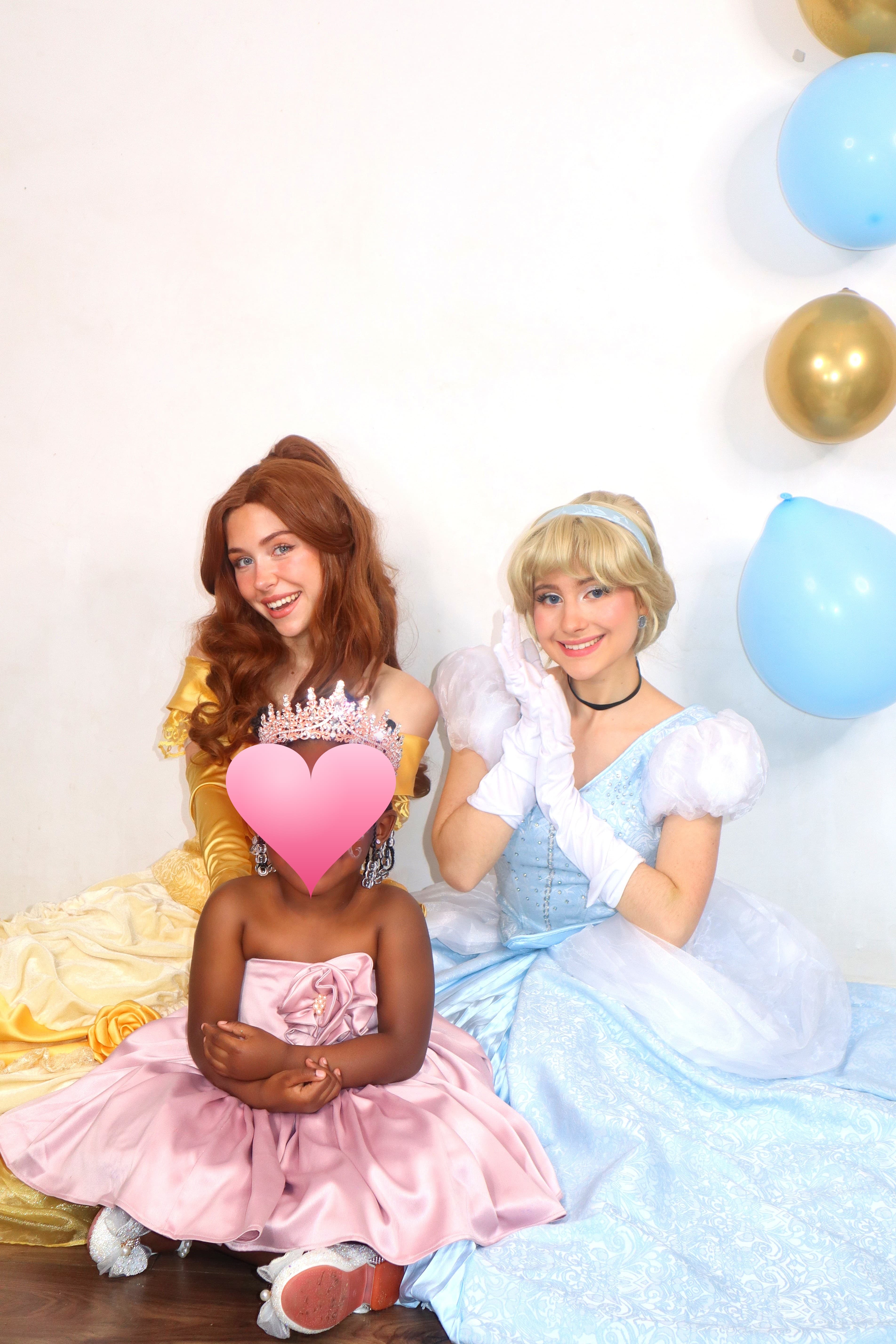 Animatrices costumées en Belle et Cendrillon avec une enfant couronnée, décor de ballons bleus et dorés