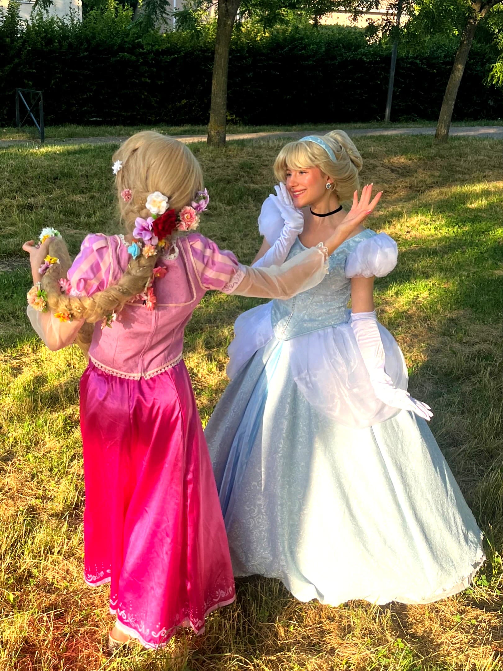 Animatrices costumées en Raiponce et Cendrillon complices dans un parc