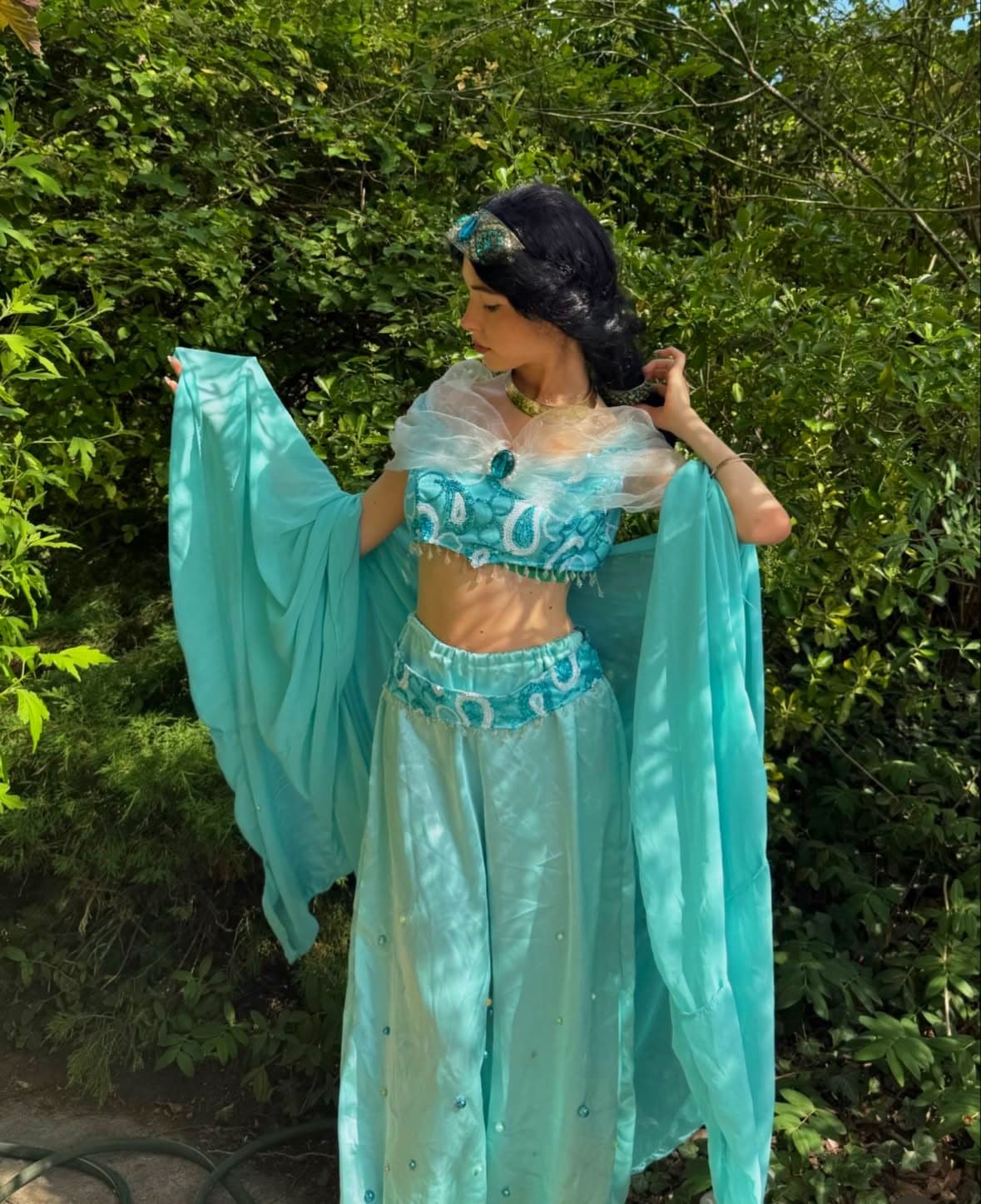 Robe Jasmine — Animatrice déguisée en Jasmine (Aladdin), tenue turquoise et voiles, dans un jardin verdoyant, lors d'une animation d'anniversaire Ma Vie de Rêves